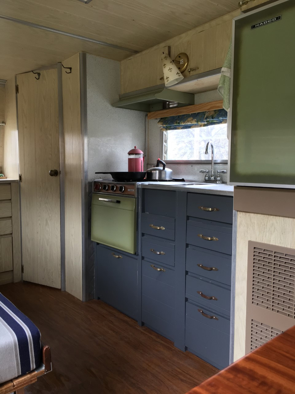 View of a kitchen inside of a vintage travel trailer. 